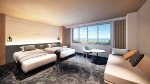 Lits jumeaux dans une chambre avec canapé et vue par la fenêtre