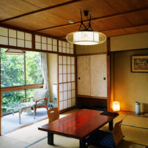 窓辺にローテーブルと椅子のある畳の客室