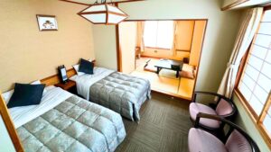 Letti singoli accanto a una zona salotto con tatami