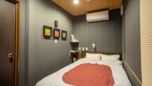 Doppelbett mit gefalteter Decke in kompaktem Gästezimmer