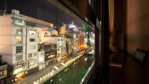 Nachtansicht von Kanal und Stadtgebäuden aus dem Fenster
