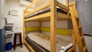 Holz-Etagenbetten mit weißer Bettwäsche im Gästezimmer