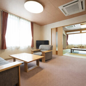带扶手椅、桌子和榻榻米休息区的客房