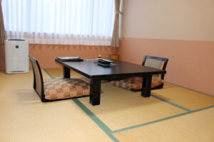 Habitación de tatami con mesa baja y sillas de suelo