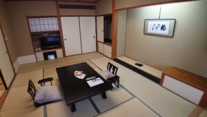 Tatami-Gästezimmer mit niedrigem Tisch und Bodenstühlen