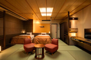Tatami-Gästezimmer mit zwei Betten und Stühlen