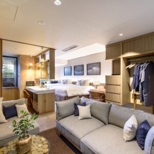 Gästezimmer mit zwei Betten, Sofa und offenem Kleiderschrank