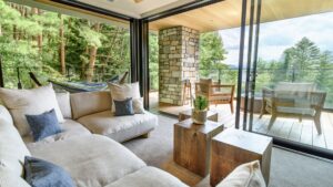 Sitzbereich mit Sofa neben offener Terrasse und Fenstern