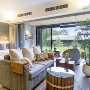 Sitzbereich mit Sofa neben Schiebetüren und Terrassenstühlen