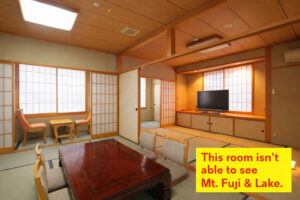 Camera in tatami con tavolo basso, sedie e televisore