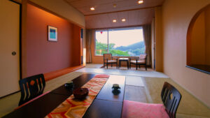 Habitación de tatami con mesa baja y sillas junto a la ventana
