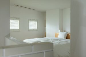 明亮简约客房内的白色床铺