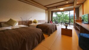 Tatami-Gästezimmer mit zwei Betten und Balkonbestuhlung