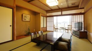 Tatami-Zimmer mit niedrigem Tisch, Bodenstühlen und Fenster