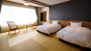 Tatami-Zimmer mit zwei Betten und Sitzplatz am Fenster