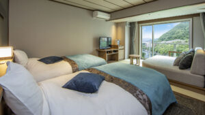 Twin beds beside window seating and mountain view