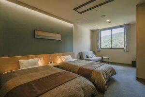 안락의자가 있는 객실의 트윈 침대