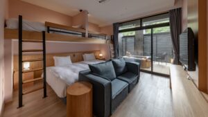 Chambre avec lits superposés, lit double, canapé et salle de bain