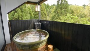 Bain privatif en plein air sur le balcon avec vue sur la forêt