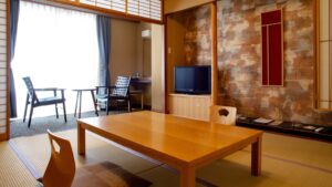 Chambre en tatami avec table basse, chaises et banquette près de la fenêtre