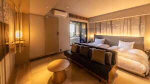 Lits jumeaux derrière un canapé dans une chambre