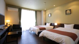 Lits jumeaux dans une chambre avec bureau et chaise