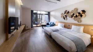 Chambre avec lits jumeaux et canapé près de la fenêtre