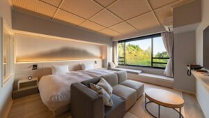 Lits jumeaux avec canapé et banquette près de la fenêtre