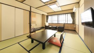 Habitación de tatami con mesa baja y sillas junto a la ventana