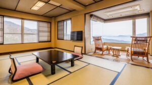 Habitación con tatami, mesa baja y sillas junto a la ventana