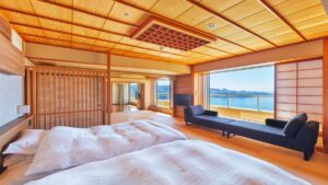 Letti in una camera tatami con divano e vista sull’oceano