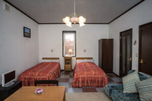 Twin beds in a guest room with sofa