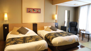 Zwei Einzelbetten in einem Gästezimmer mit Stuhl und Tisch