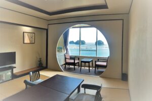 榻榻米客房，窗边有桌椅，可欣赏海景