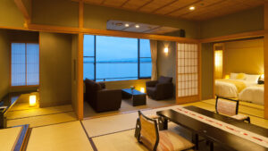 Habitación de tatami con mesa baja, sillas y camas