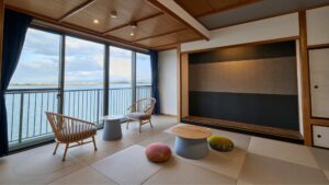 Habitación de tatami con sillas y ventanas frente al lago