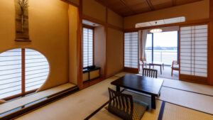 Habitación de tatami con mesa baja y sillas junto a la ventana