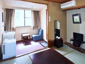 Tatami guest room with chair, table, and television