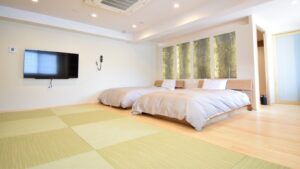 Twin beds beside tatami flooring in guest room