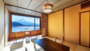Habitación de tatami con mesa baja y asientos junto a la ventana.