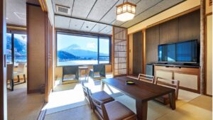 Habitación de tatami con mesa baja, sillas y vista por la ventana