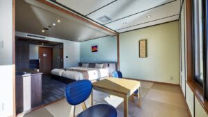 Dos camas individuales y una mesa en una habitación de tatami