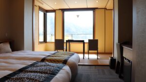 Camas individuales junto a una mesa y sillas junto a la ventana