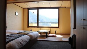 Camas individuales junto a una zona de tatami y vista por la ventana