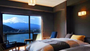 Camas individuales junto a la ventana con vistas al monte Fuji