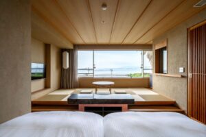 畳の座席スペースとオーシャンビューに面したツインベッド