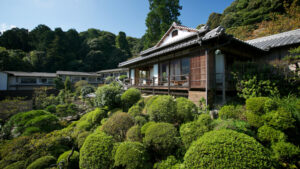 Traditionelles Ryokan-Gebäude, umgeben von einem angelegten Garten