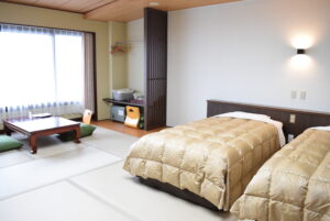 Lits jumeaux à côté d’un coin salon en tatami