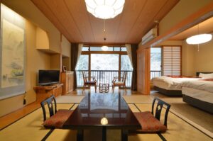 낮은 테이블, 의자, 침대가 있는 다다미방