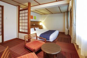 더블 침대와 의자, 원형 테이블이 있는 침실